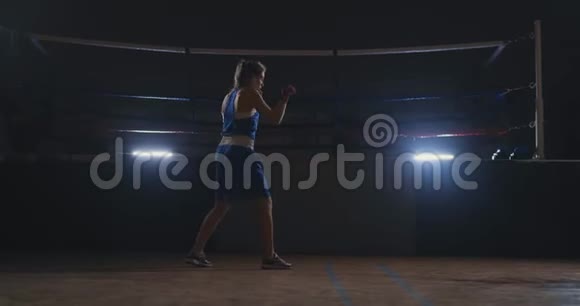 穿着红色绷带的漂亮女战士在健身房锻炼时进行影子搏斗慢动作Stealam射击视频的预览图