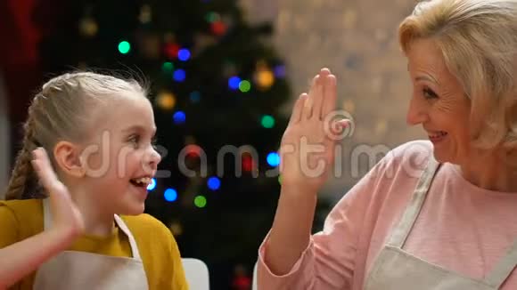 妈妈和女儿穿着围裙送高五很高兴准备圣诞晚餐视频的预览图