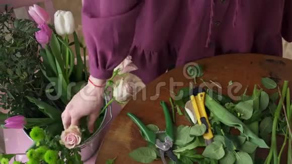 女性花店清洁玫瑰茎叶俯视视频的预览图