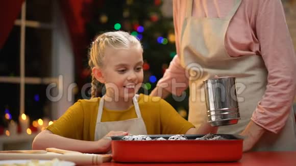 女孩用糖洒上传统的圣诞松饼童年的美好回忆视频的预览图