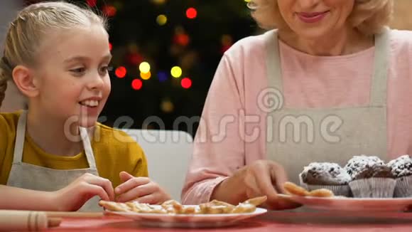 女孩用纸杯蛋糕吹糖粉和奶奶一起笑一起玩视频的预览图