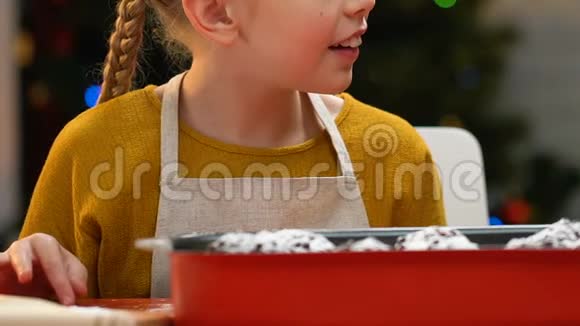 小女孩偷偷吃小蛋糕从节日桌上偷糖果特写视频的预览图