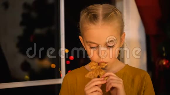 可怜的女孩吃着圣诞饼干站在窗边孤儿慈善组织视频的预览图