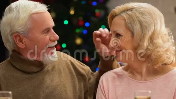 老人温柔地亲吻妻子庆祝圣诞节一起快乐到老年视频的预览图