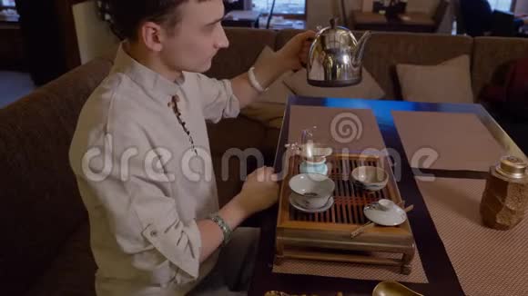 在传统仪式中人们用干茶从水壶里倒热水视频的预览图