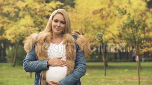 乐观的孕妇微笑着看着镜头计划生育等待视频的预览图