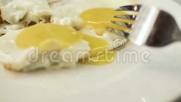 煎蛋中的蛋黄用铁叉从上面刺穿视频的预览图
