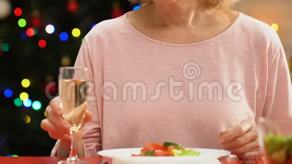 一个孤独的寡妇在镜头前微笑喝着香槟心烦意乱视频的预览图
