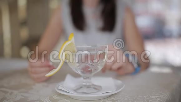 女人在餐厅吃了油腻的食物后在一碗柠檬水中洗手视频的预览图