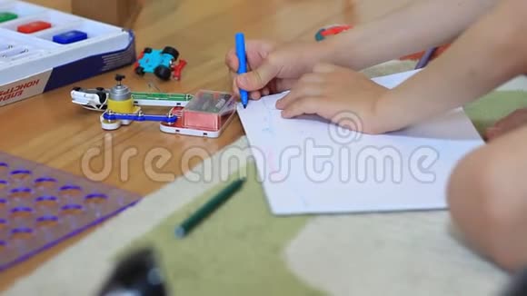 一个小男孩的手在一张纸上画画视频的预览图