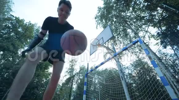 有着仿生机器人手臂的青少年正在玩一个球并试图击中篮子视频的预览图