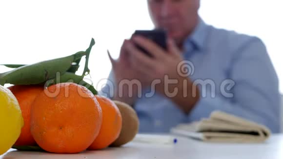 使用手机报纸和桌上新鲜水果放松的男士文本视频的预览图