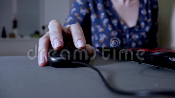 女人拿着电脑鼠标点击滚动关闭女士晚上在家里在黑暗中工作电脑视频的预览图