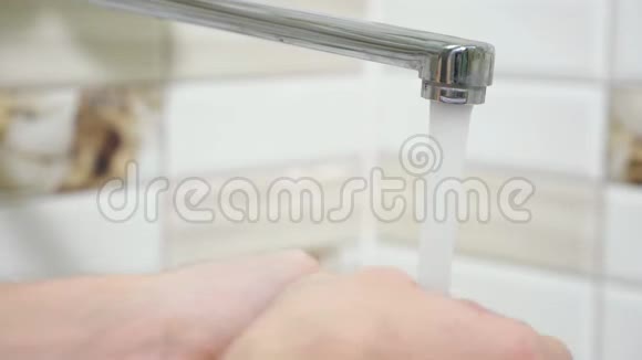 男人在水龙头下的浴室里洗手视频的预览图