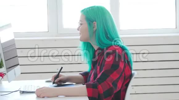 自由职业者或办公室工作的概念年轻的女平面设计师有彩色头发在办公室或家里工作视频的预览图