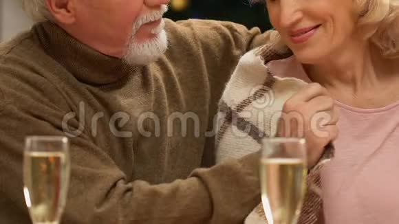 老丈夫用毯子轻轻地裹着妻子快乐而安全地退休视频的预览图