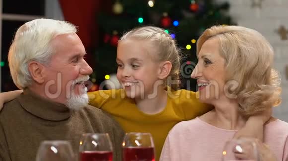爷爷奶奶亲吻可爱的孙女老两口高兴在圣诞节见到孩子视频的预览图