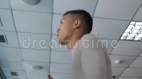 年轻的亚洲人正在健身房的跑步机上跑步视频的预览图