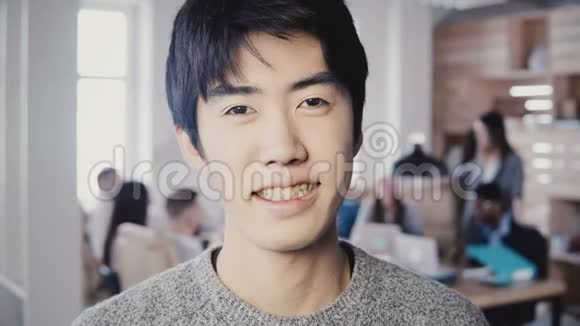 成功的亚洲男性创意经理在现代办公室微笑的特写肖像英俊的男人看着4K相机视频的预览图