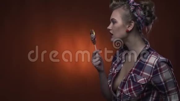 一个留着漂亮发型的漂亮姑娘正在慢慢舔她的棒棒糖视频的预览图