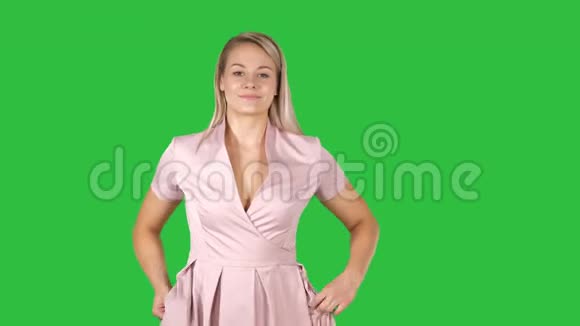 女孩走路的肖像双手插在绿色屏幕上的粉红色衣服口袋里Chroma键视频的预览图
