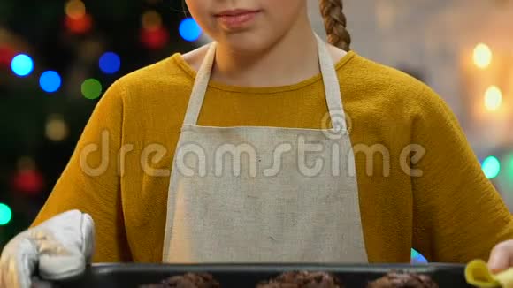 小女孩拿着蛋糕放在烤盘里为自己做糖果而自豪视频的预览图
