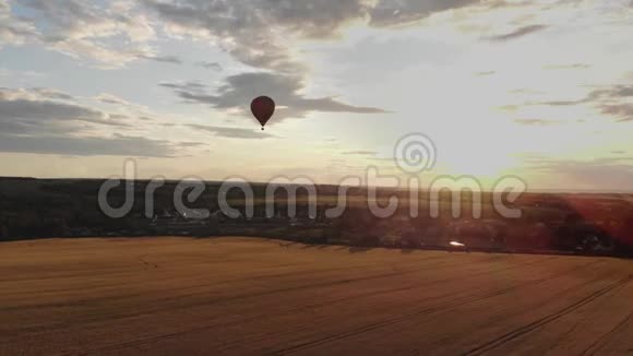 空中景色美丽的日落时分热气球在乡间田野上空盘旋视频的预览图