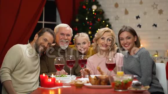 一家人坐在桌子旁吃着传统的圣诞晚餐看着镜头放大视频的预览图