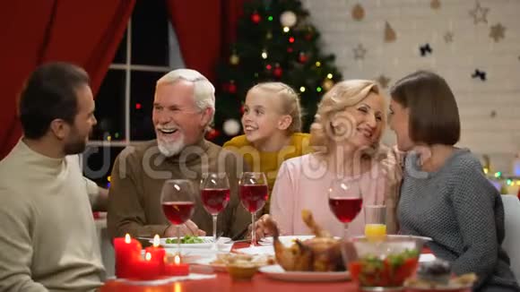 快乐的一家人在圣诞晚餐上聊天讲有趣的故事圣诞节奇迹般的时刻视频的预览图