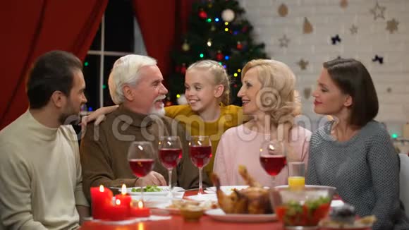 祖父母亲吻小女孩大家庭吃圣诞晚餐快乐时光视频的预览图