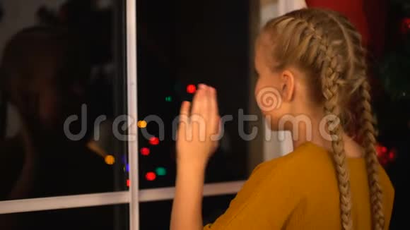 快乐的女孩从窗外挥手跑开和亲戚们一起参加圣诞晚会视频的预览图