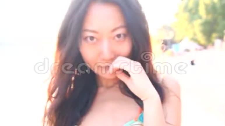美丽苗条的亚洲年轻女子穿着泳装在海滩上奔跑喜欢在海上放松视频的预览图