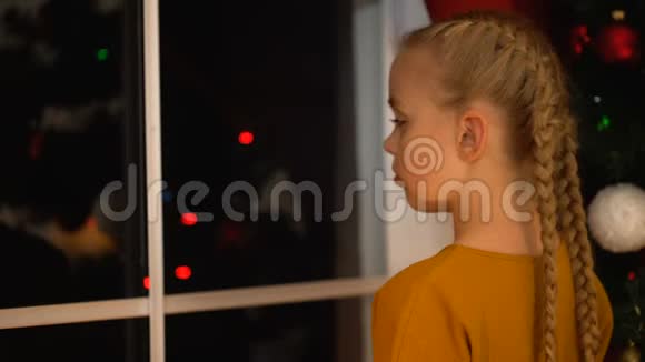 窗外忧伤孤独的女孩转身望着镜头圣诞节在孤儿之家视频的预览图