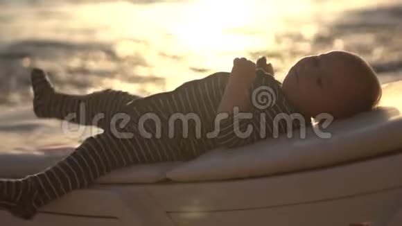 可爱的婴儿在日落时用面包慢慢地休息视频的预览图