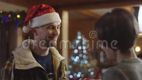 圣诞老人的丈夫送给他幸福的妻子一份圣诞礼物然后进屋视频的预览图