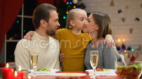 圣诞晚餐快乐的家庭女儿亲吻父母装饰闪烁视频的预览图