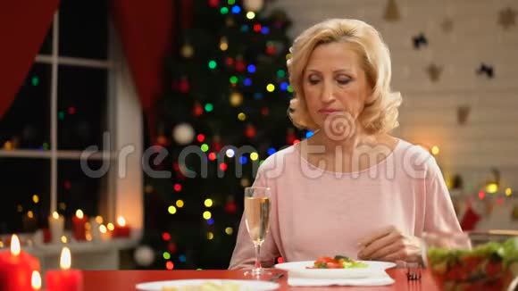 悲伤孤独的女性在圣诞前夜喝着香槟回忆着快乐的时光视频的预览图