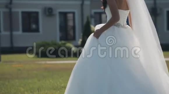 婚礼前美丽的新娘走在外面女人停下来穿着婚纱转身慢动作视频的预览图
