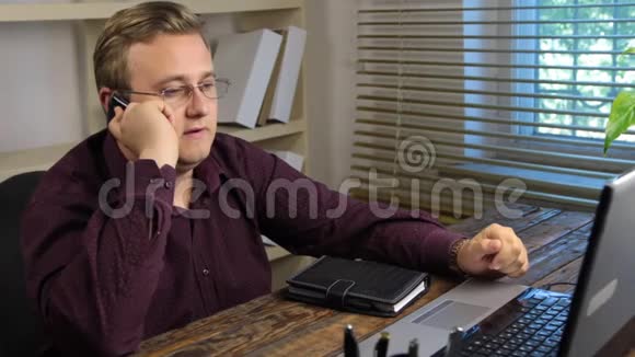 商人坐在电脑前用手机说话对谈话不满意视频的预览图