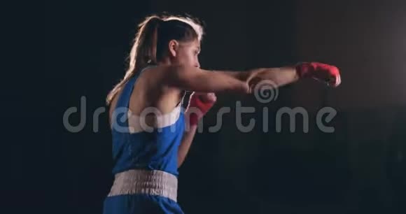 穿着红色绷带的漂亮女战士在健身房锻炼时进行影子搏斗慢动作Stealam射击视频的预览图