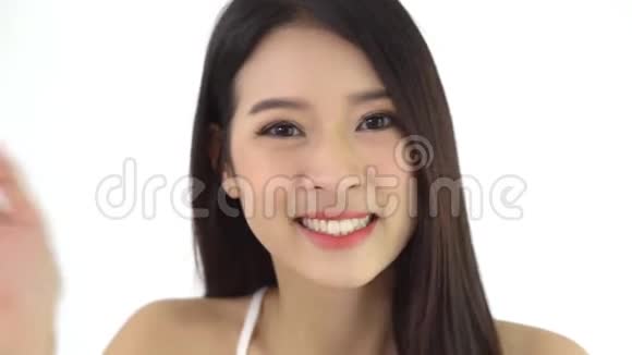 美丽的亚洲年轻女子坐在电视上打电话聊天向家里的某人问好和亲吻视频的预览图