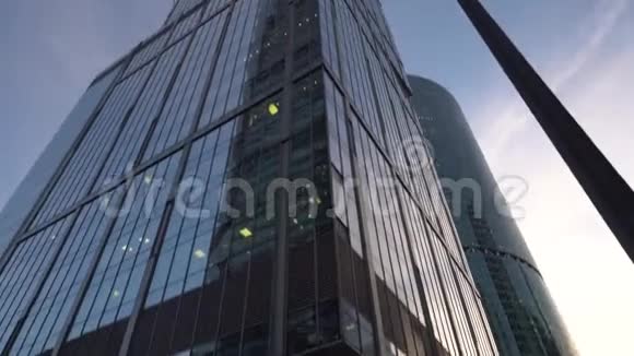 不寻常形状的现代摩天大楼由玻璃制成在旋转中观看白天视频的预览图