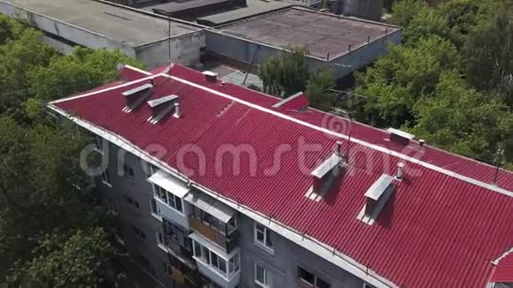 鸟瞰多层住宅建筑明亮的粉红色屋顶除其他房屋和绿树外股票视频的预览图