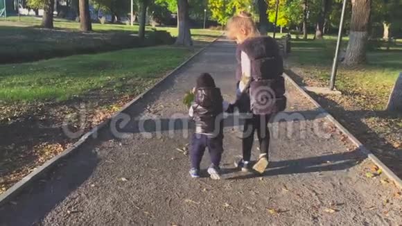 秋日公园美女牵着手领着小弟弟出门视频的预览图
