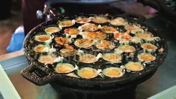 泰国的街头美食在KanomKrok铁锅里用贻贝煮鸡蛋视频的预览图