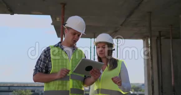 一栋在建建筑的主管男子与工程师设计师妇女讨论施工进度和视频的预览图