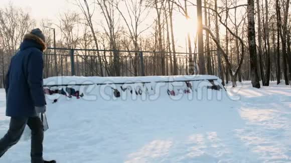 人们坐在雪地里的溜冰场上雪在山上漂移到滑板上视频的预览图