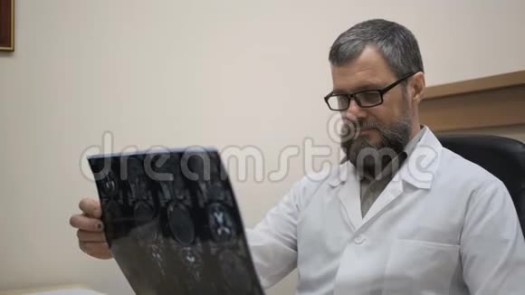 医生看了一张电脑断层扫描和核磁共振的照片视频的预览图