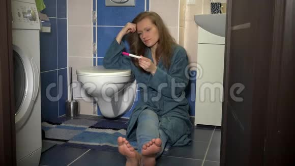 在浴室做怀孕测试的不高兴的女人正负结果概念视频的预览图