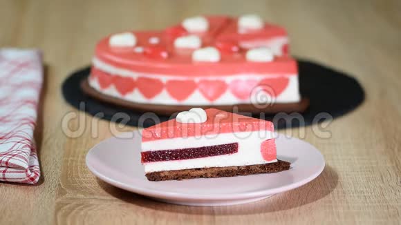 盘子里的一块红莓慕斯蛋糕情人节那天装饰精美的心形慕斯蛋糕视频的预览图